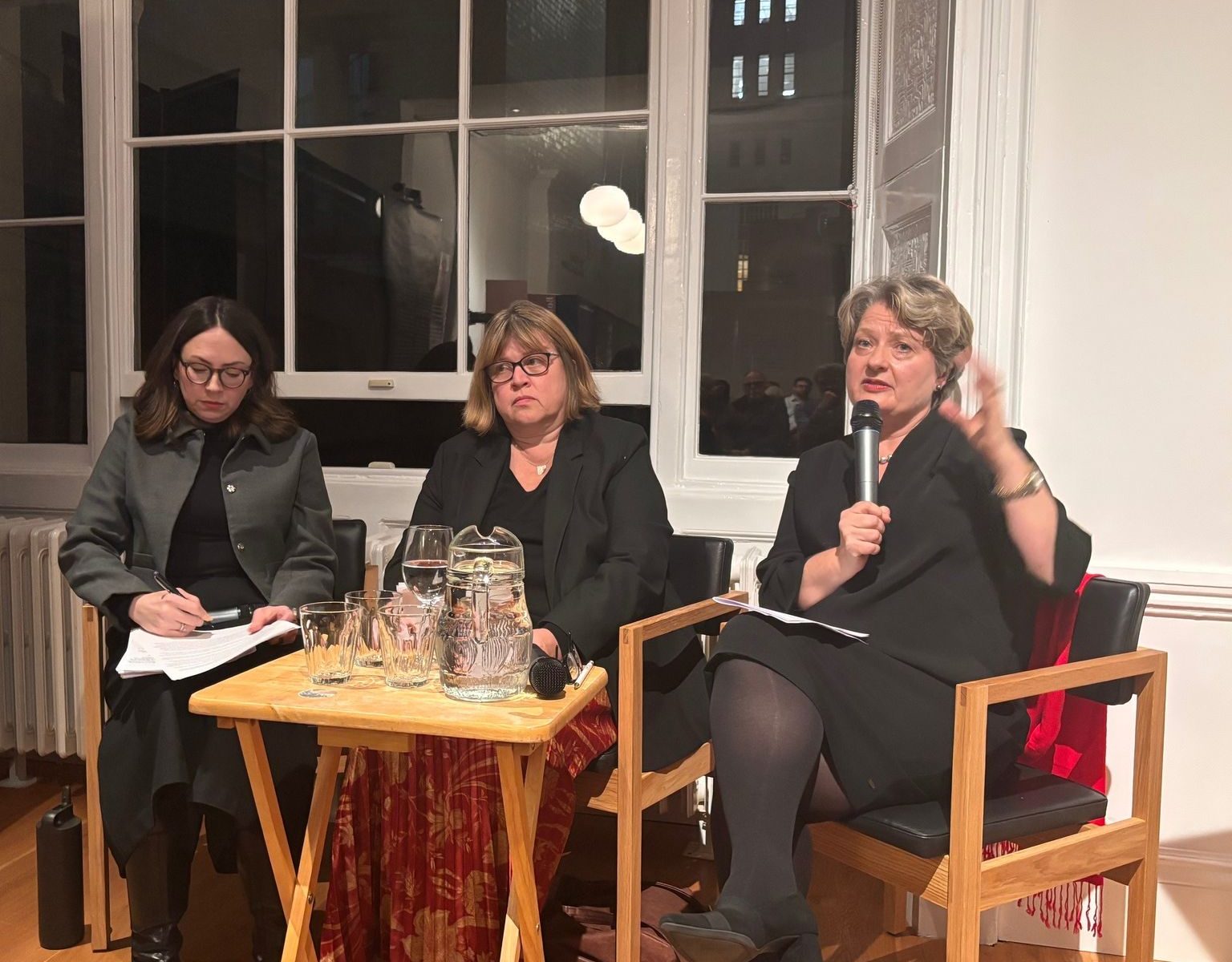 women speaking in a panel with microphones